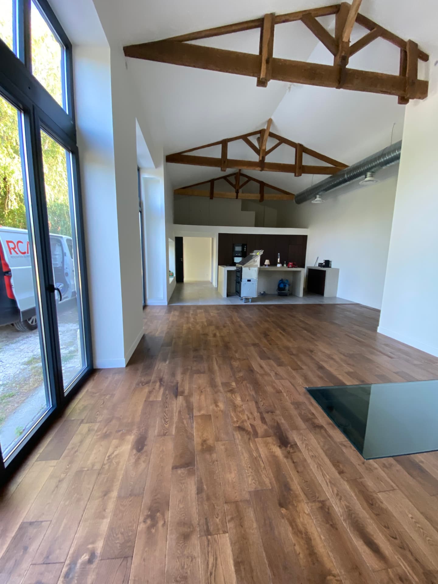 Grande pièce de vie rénovée avec parquet et charpente apparente