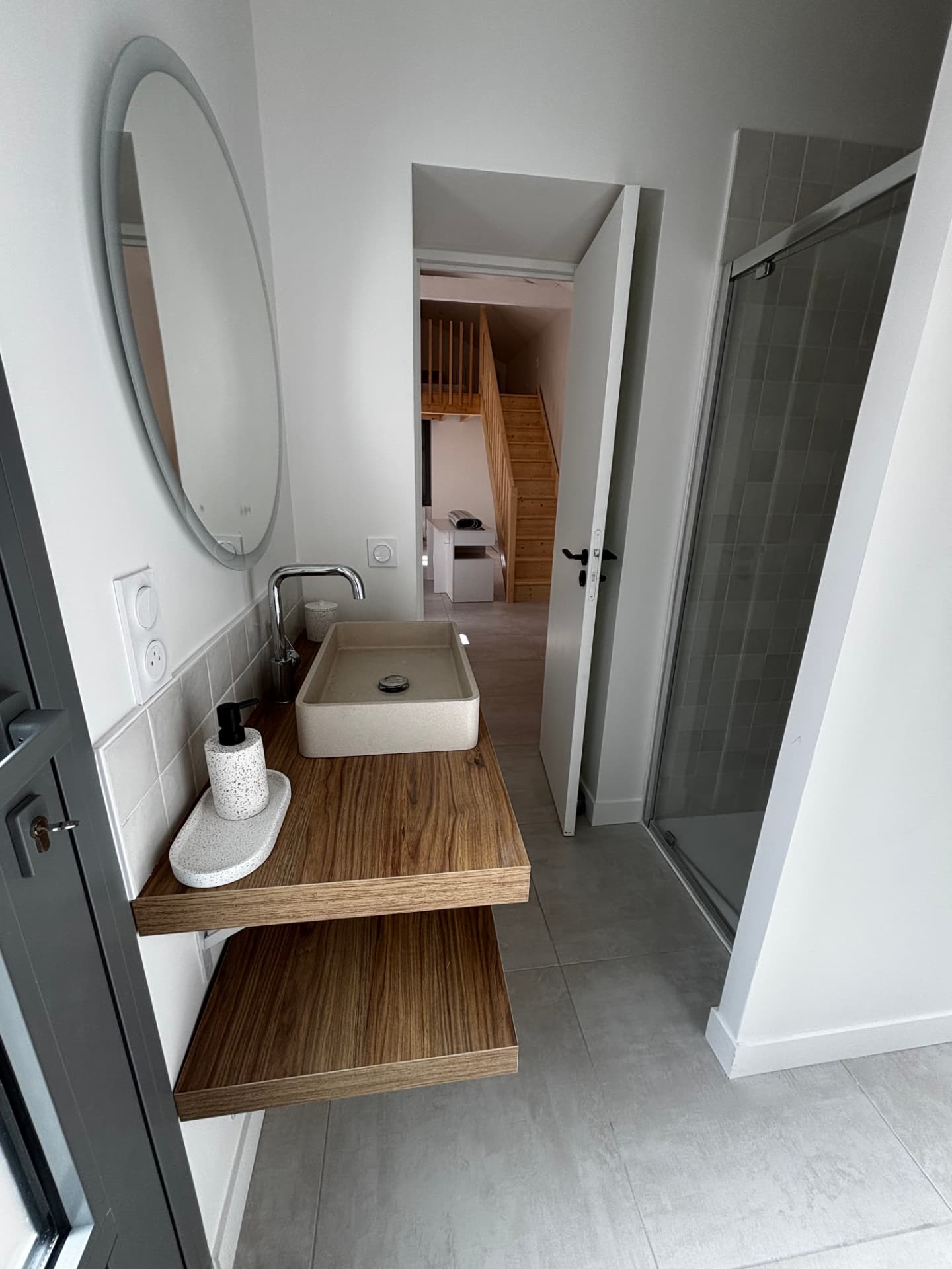 Salle d’eau rénovée avec meuble vasque en bois et douche